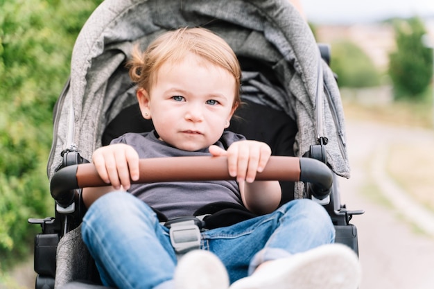 Portrait d'un petit enfant assis à l'intérieur d'un landau