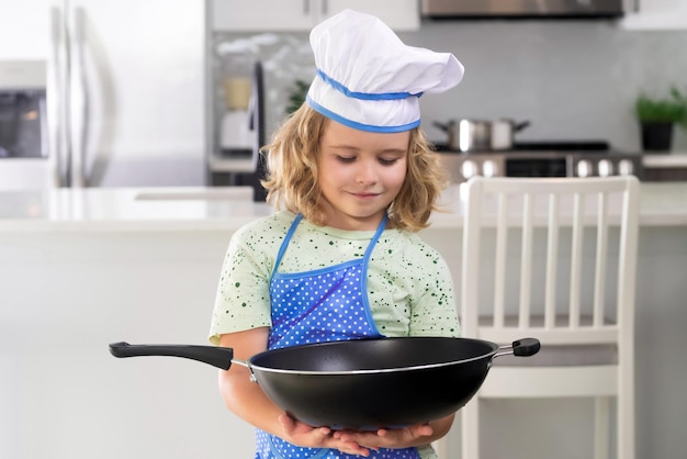 Portrait d'un petit enfant drôle en chapeau de chef