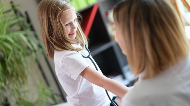 Portrait d'un petit enfant heureux utilisant un stéthoscope médical lors d'un rendez-vous chez le médecin