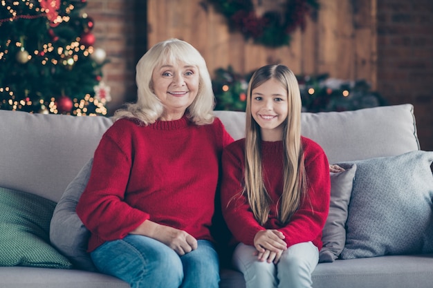 Portrait de petit-enfant mamie s'asseoir sur le divan passer la veille de vacances noel au loft intérieur maison à l'intérieur