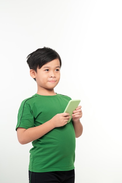 Portrait d'un petit enfant mignon satisfait jouant à des jeux sur smartphone isolated over white