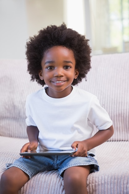 Portrait d&#39;un petit garçon à l&#39;aide de tablette numérique