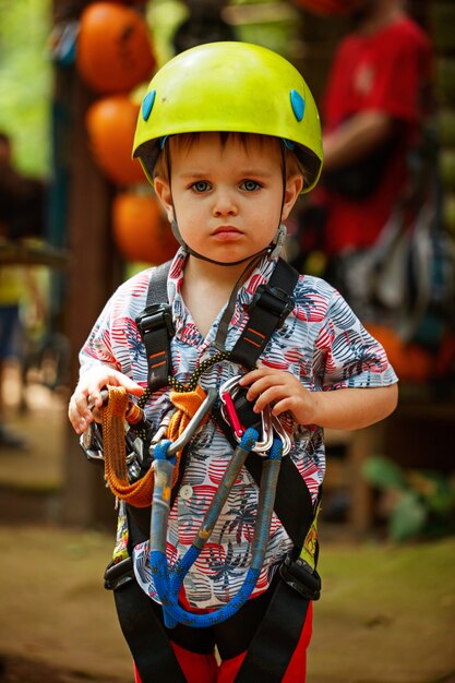 Portrait, petit garçon, amusement, dans, aventure, parc, loking, à, camera, porter, casque, et, sécurité, équipement