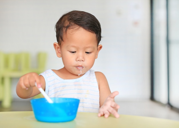 Portrait, de, petit garçon asiatique, manger, céréale, à, cornflakes, et, lait