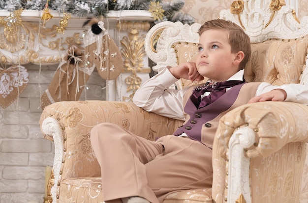 Portrait de petit garçon assis sur une chaise à Noël