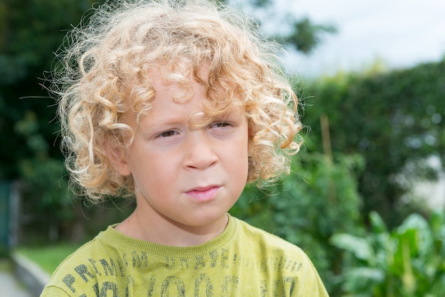 Portrait de petit garçon aux cheveux blonds et bouclés