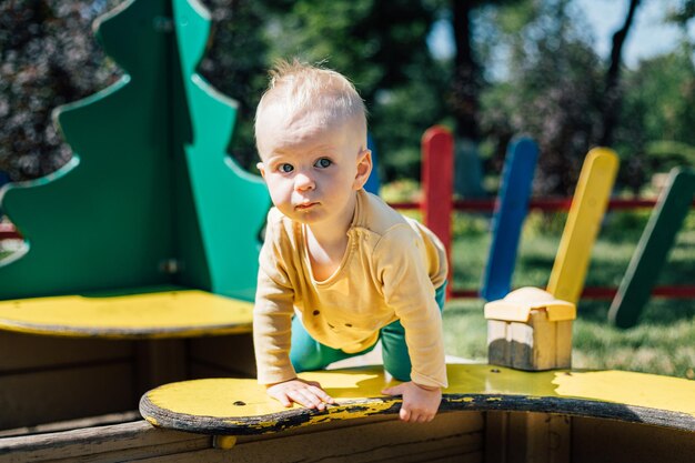 portrait d'un petit garçon blond sur une aire de jeux