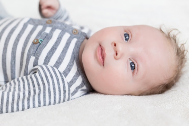 Portrait d'un petit garçon dans un bonnet sur fond blanc