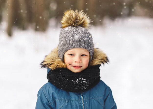 Portrait d'un petit garçon dans un chapeau en hiver dans le parc