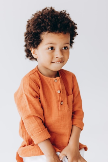 Photo portrait d'un petit garçon élégant qui rit sincèrement avec un beau sourire