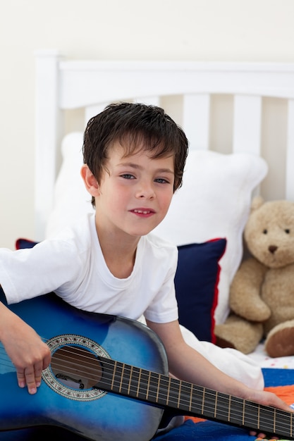 Portrait d&#39;un petit garçon jouant de la guitare