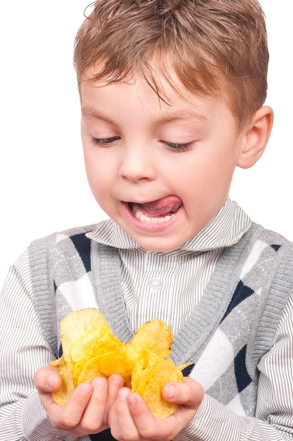 Portrait d'un petit garçon joyeux avec un paquet de chips de pommes de terre Close-up d'un enfant mangeant de la restauration rapide isolé sur un fond blanc