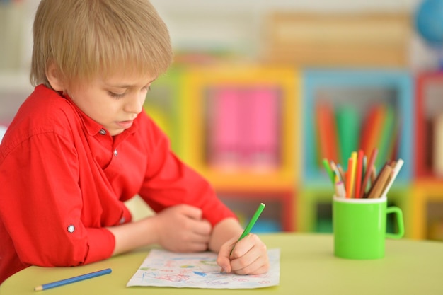 Portrait de petit garçon mignon dessinant avec des crayons