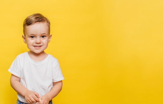 Portrait d'un petit garçon riant mignon sur le jaune