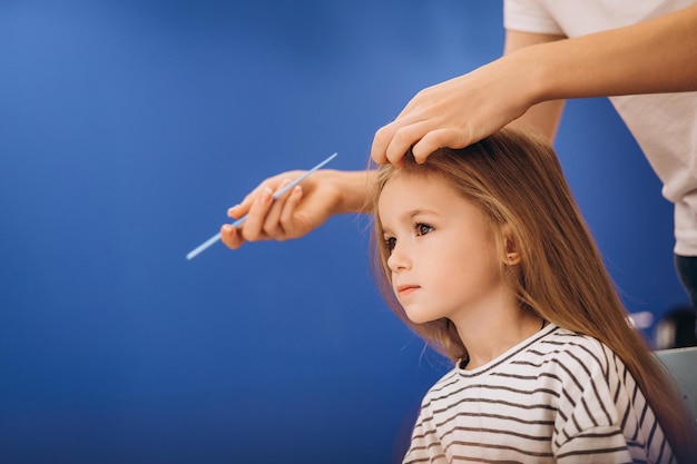 Portrait d'une petite belle fille avec une coiffure élégante dans un salon de beauté