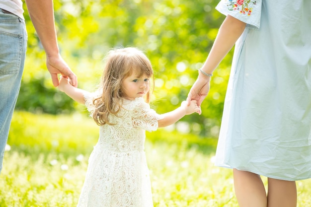 Photo portrait d'une petite belle petite fille marchant main dans la main avec ses parents en gros plan