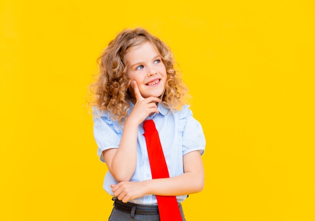 Portrait d'une petite écolière tenant un livre au-dessus de sa tête. Fond isolé. Notion d'éducation.