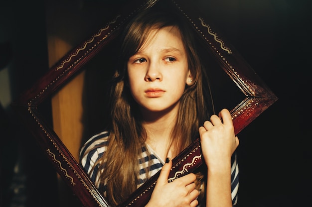 Portrait de petite femme dans un cadre en bois