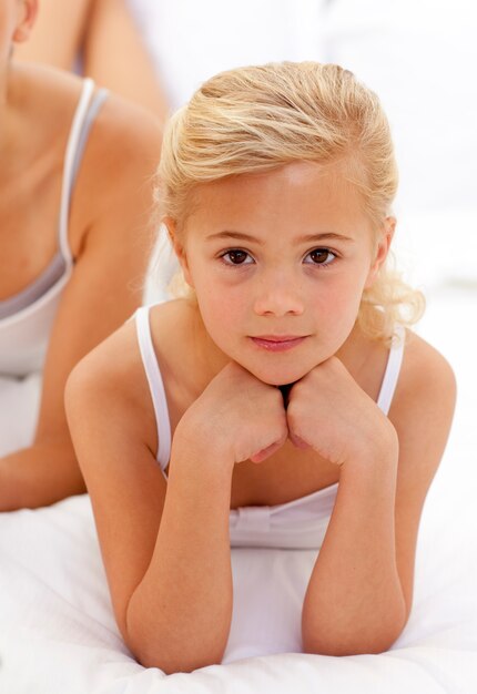 Photo portrait d'une petite fille allongée sur le lit