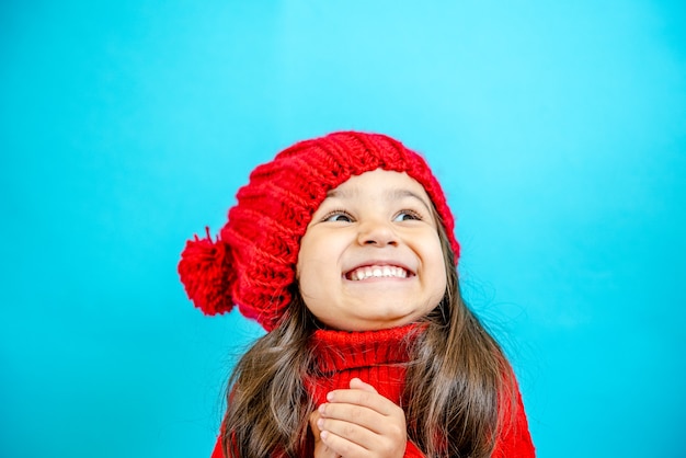 portrait d'une petite fille aux cheveux bouclés dans un chapeau rouge tricoté en hiver petite fille aux cheveux noirs