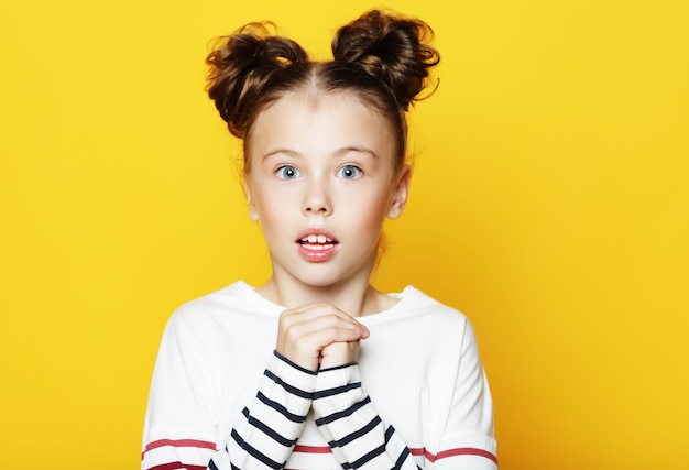 Portrait de petite fille avec la bouche ouverte et l'expression folle Visage surpris ou choqué