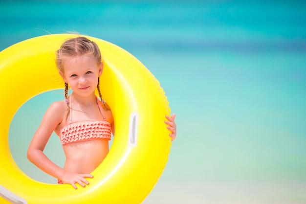 Portrait de petite fille avec un cercle en caoutchouc gonflable sur les vacances à la plage
