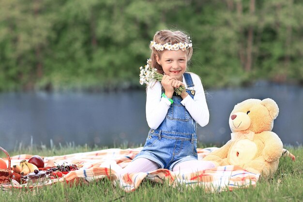 Portrait d'une petite fille dans une couronne avec une peluche près du r