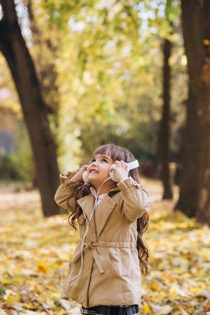 Portrait petite fille dans un manteau beige se promène dans le parc de l'automne
