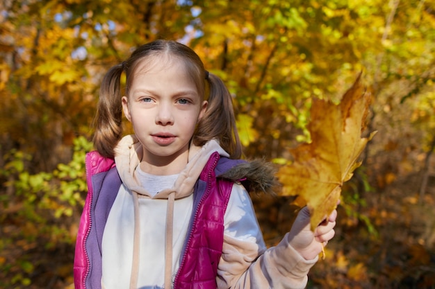 Portrait d'une petite fille dans un parc d'automne par une journée ensoleillée