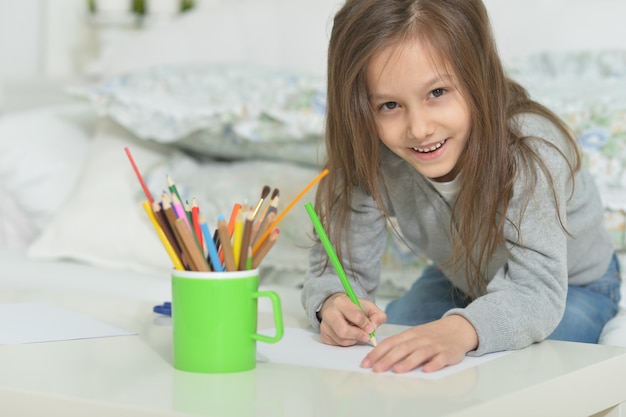 Portrait de petite fille dessinant à la maison