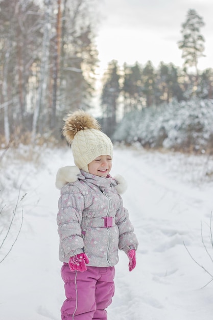 Le portrait de la petite fille est la forêt enneigée en hiver