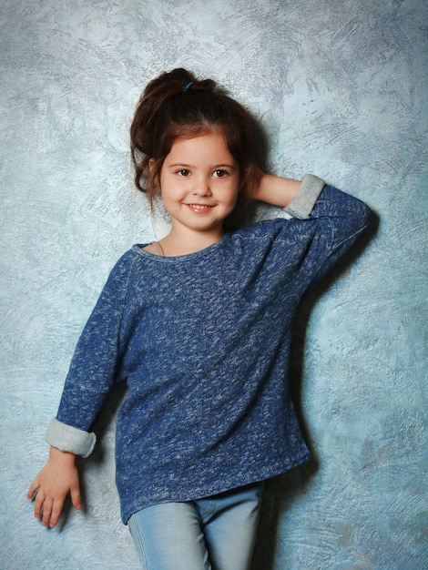 Portrait de petite fille fashion kid sur fond de mur gris