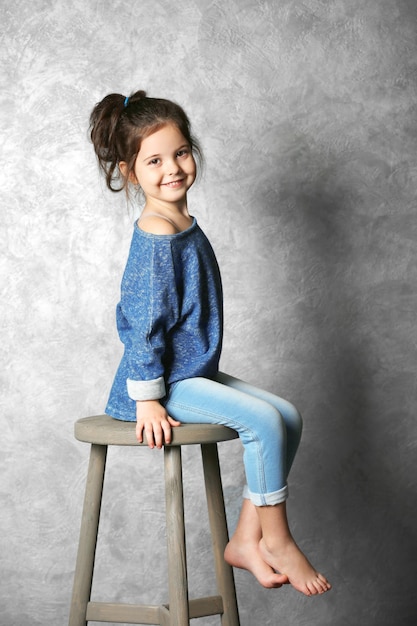 Portrait de petite fille fashion kid sur fond de mur gris