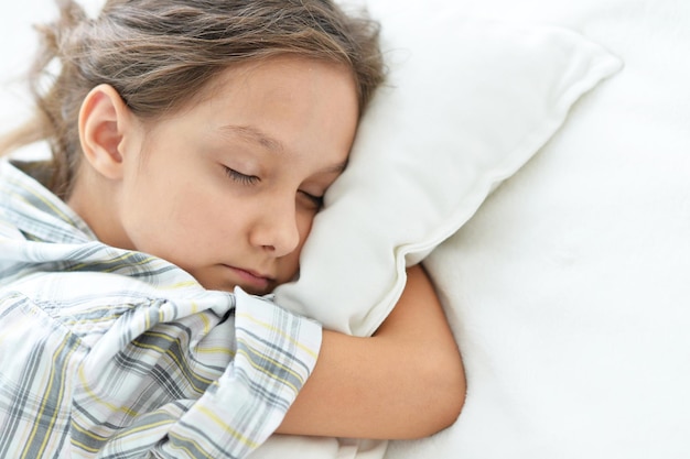 Portrait d'une petite fille fatiguée dormant dans son lit