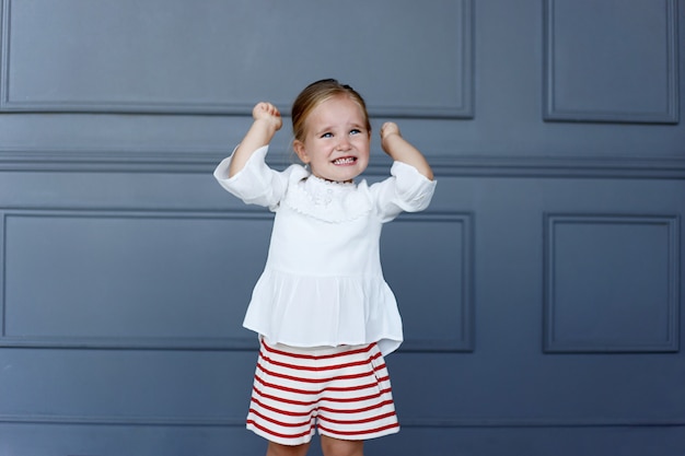 Le portrait d'une petite fille frustrée lève les mains