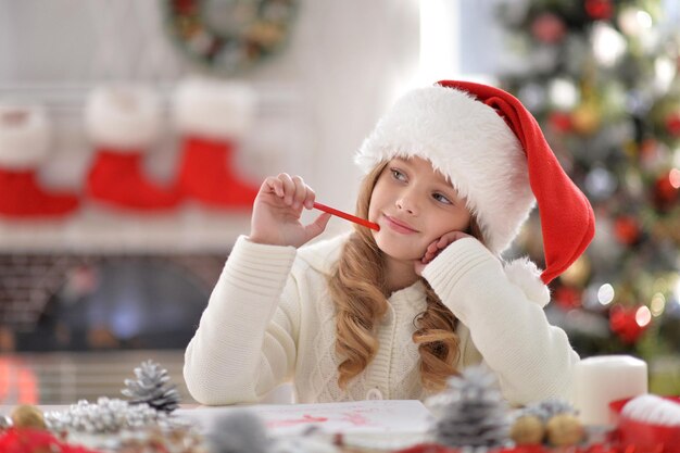 Portrait d'une petite fille heureuse avec un chapeau de Père Noël