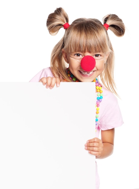 Portrait d'une petite fille heureuse avec un nez de clown rouge avec un blanc blanc isolé sur fond blanc