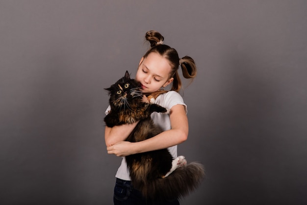 Portrait d'une petite fille jouant avec son animal de compagnie, gros chat noir