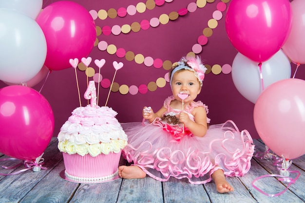 Portrait d'une petite fille joyeuse d'anniversaire avec le premier gâteau