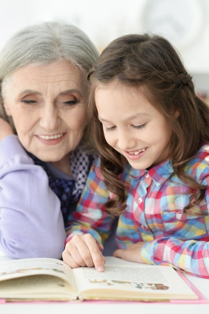 Portrait de petite fille lisant avec sa grand-mère
