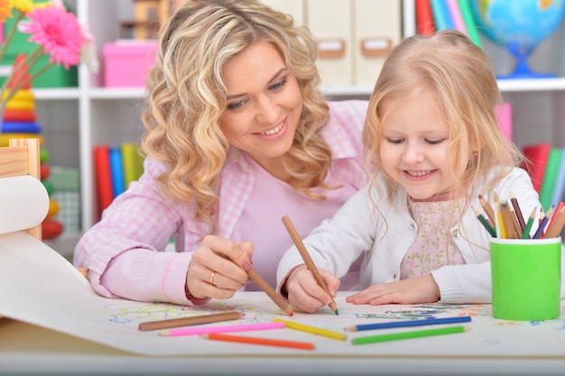 Portrait de petite fille et mère dessinant avec des crayons