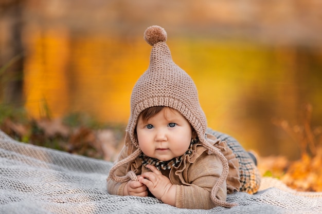 Portrait de petite fille mignonne dans le parc en automne sur une couverture