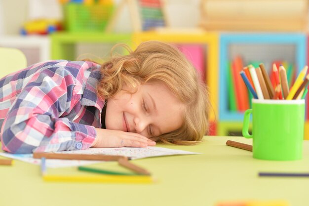 Portrait d'une petite fille mignonne dormant sur la table