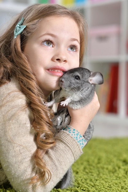 Portrait d'une petite fille mignonne jouant avec le chinchilla