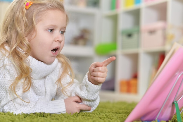 Portrait d'une petite fille mignonne lisant un livre