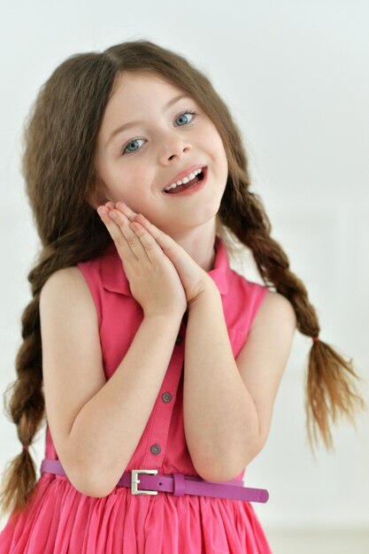 Portrait de petite fille mignonne posant dans la robe rose