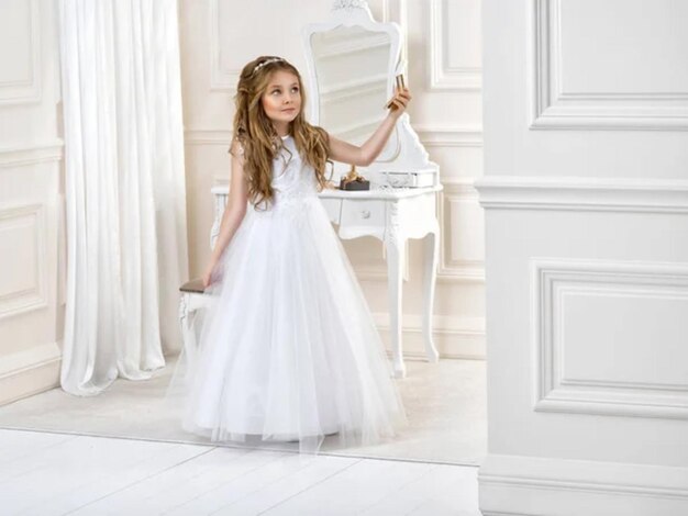 Portrait d'une petite fille mignonne en robe blanche et en couronne