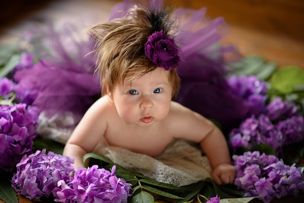 Portrait d'une petite fille mignonne (six mois). Bébé se trouve aux couleurs de l'hortensia violet