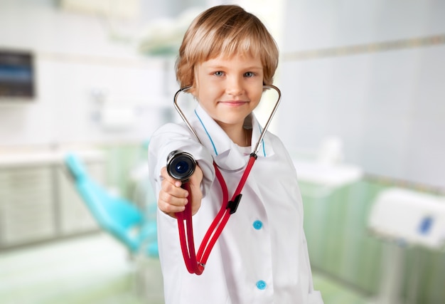 Photo portrait d'une petite fille mignonne tenant dans sa main un stéthoscope jouant au docteur