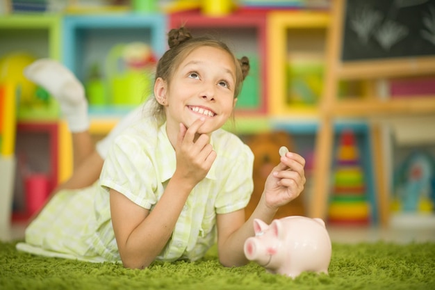 Portrait de petite fille mignonne avec une tirelire